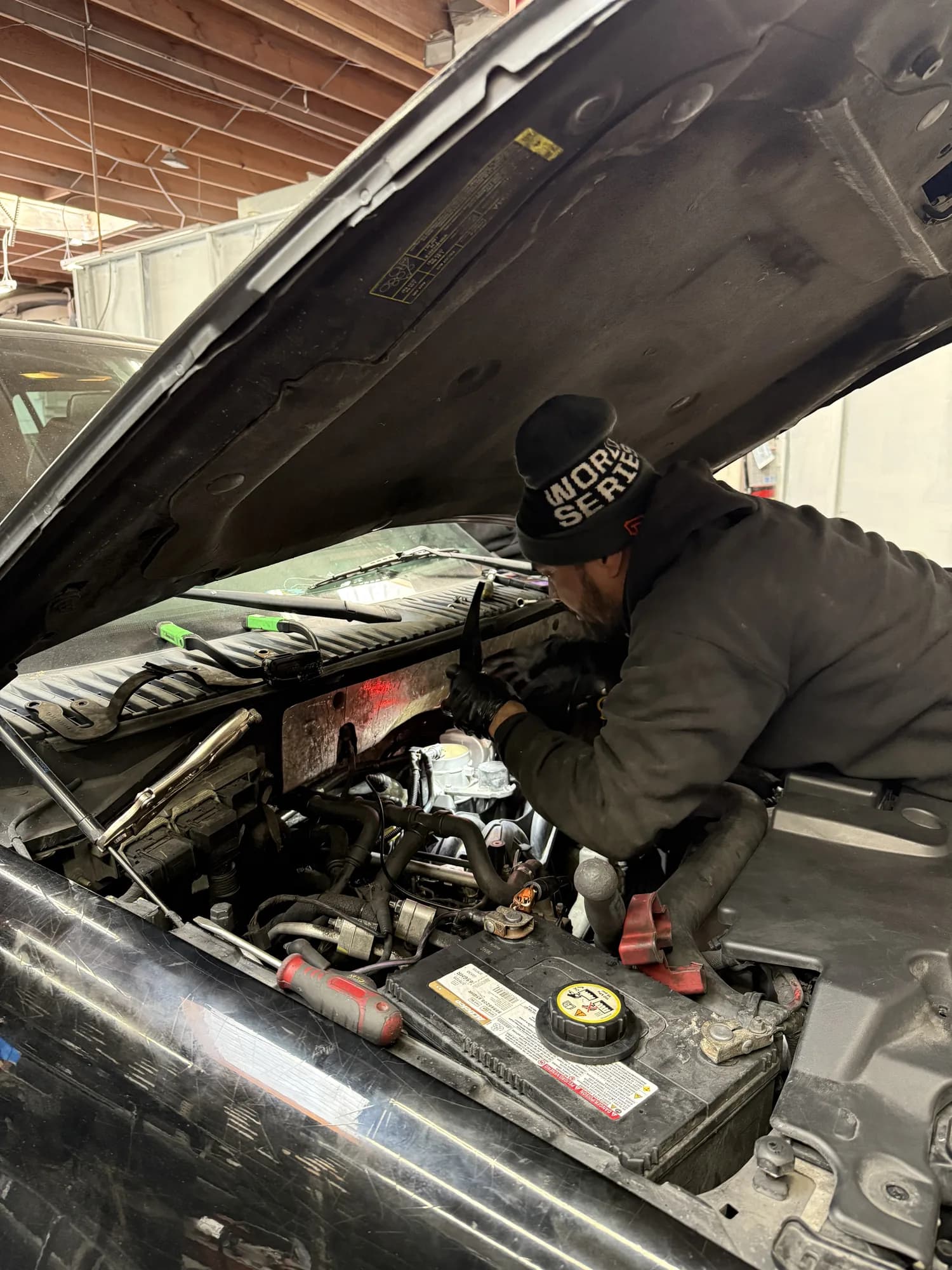 Wu's Auto Center technician working in an engine bay
